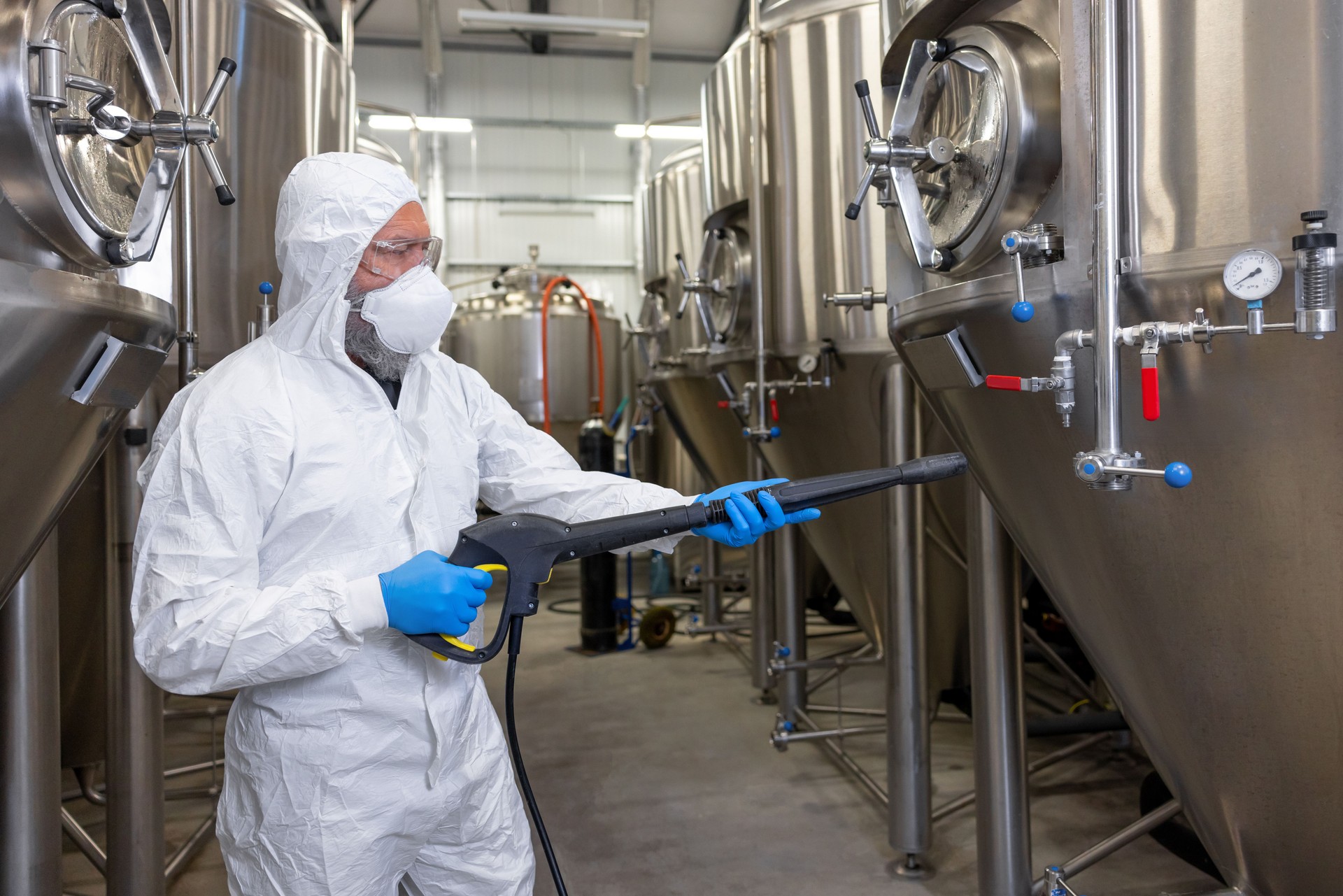 Experienced beer tech cleaning and sanitizing the brewing equipment Experienced beer tech cleaning and sanitizing the brewing equipment